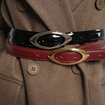 Close-up of a coat with a red belt featuring gold buckle and black belt with silver buckle - Streets Ahead