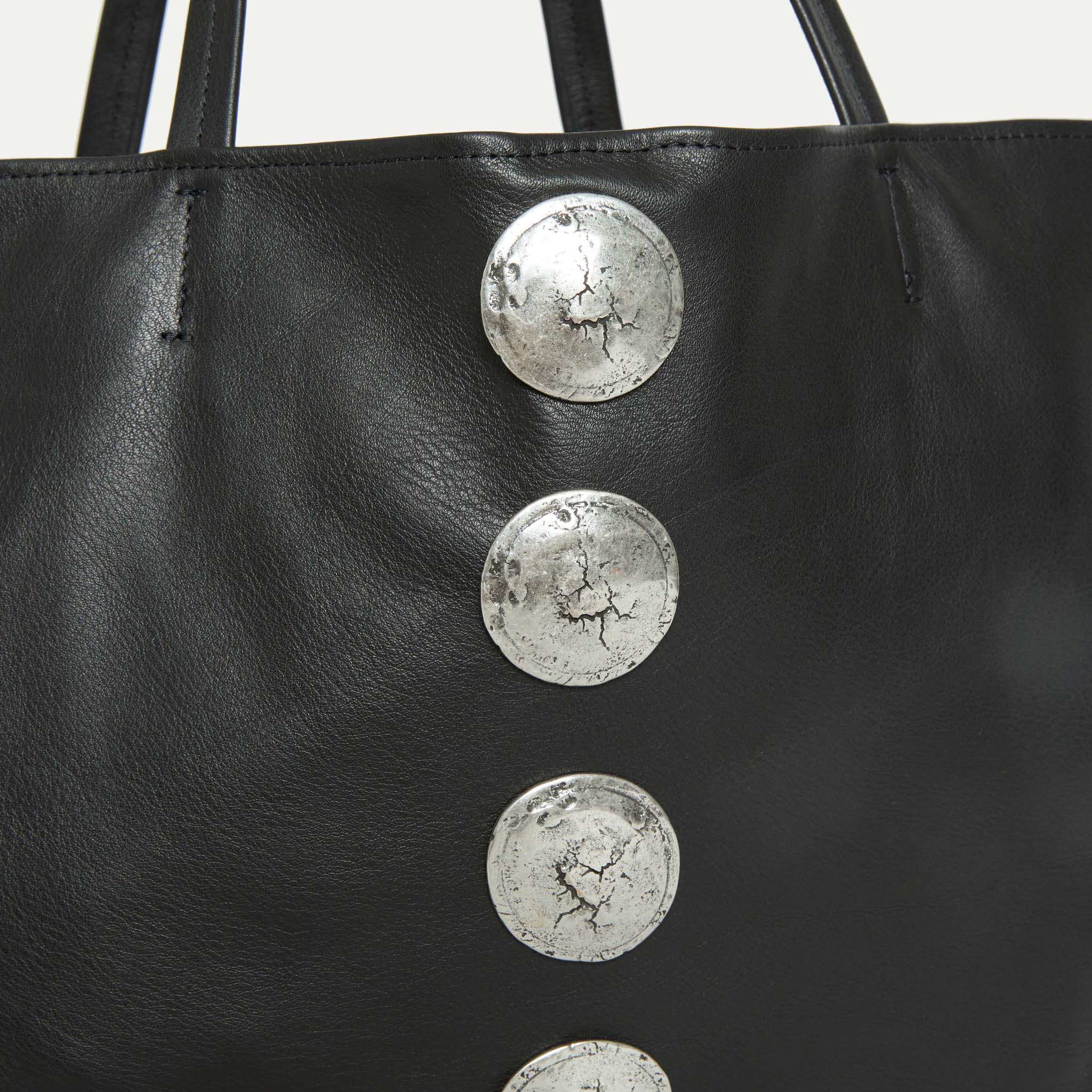Close-up of silver Italian hardware detail on the Gaia Slouchy Tote in black leather.
