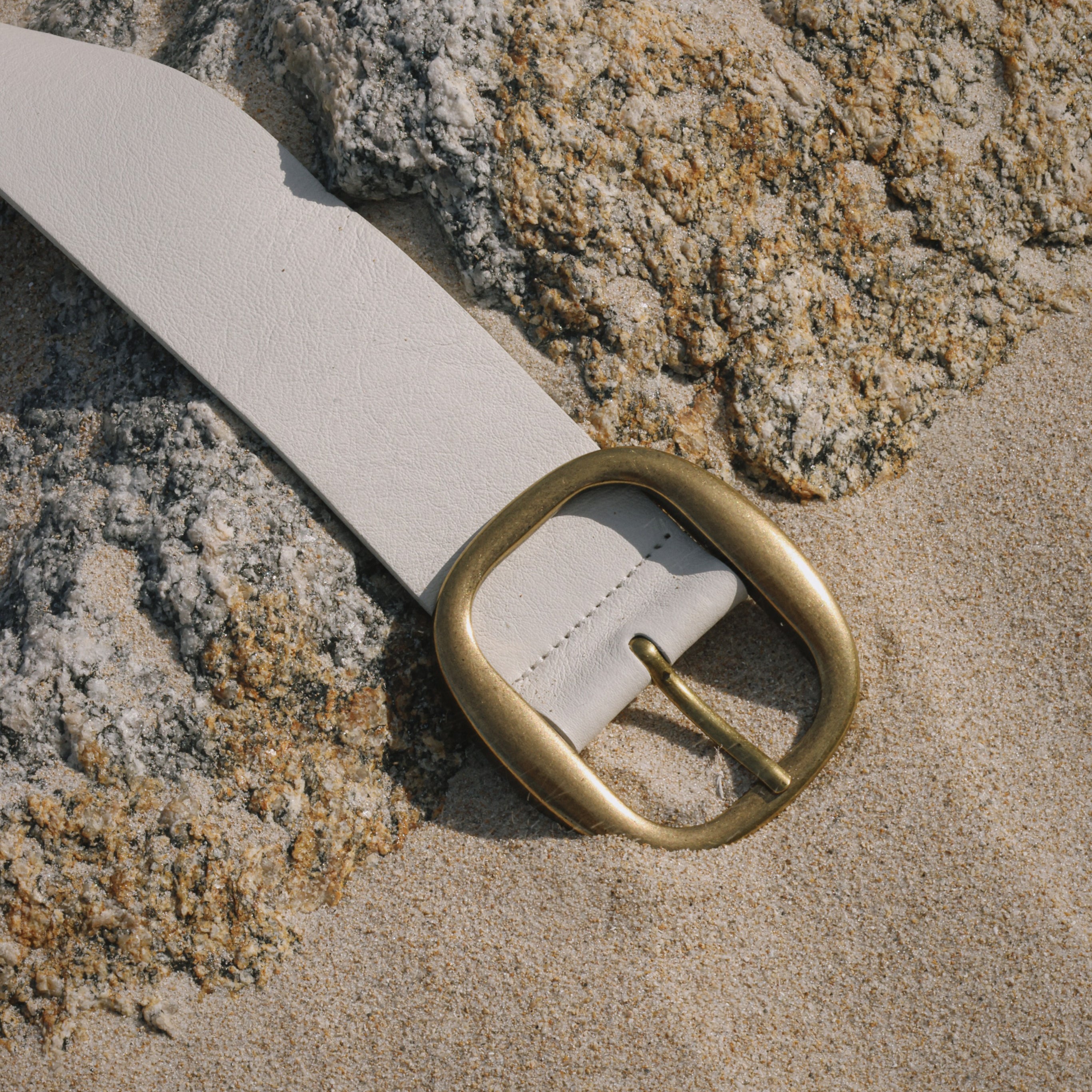 White Italian leather belt with brass-plated buckle, handcrafted in Los Angeles using custom hardware