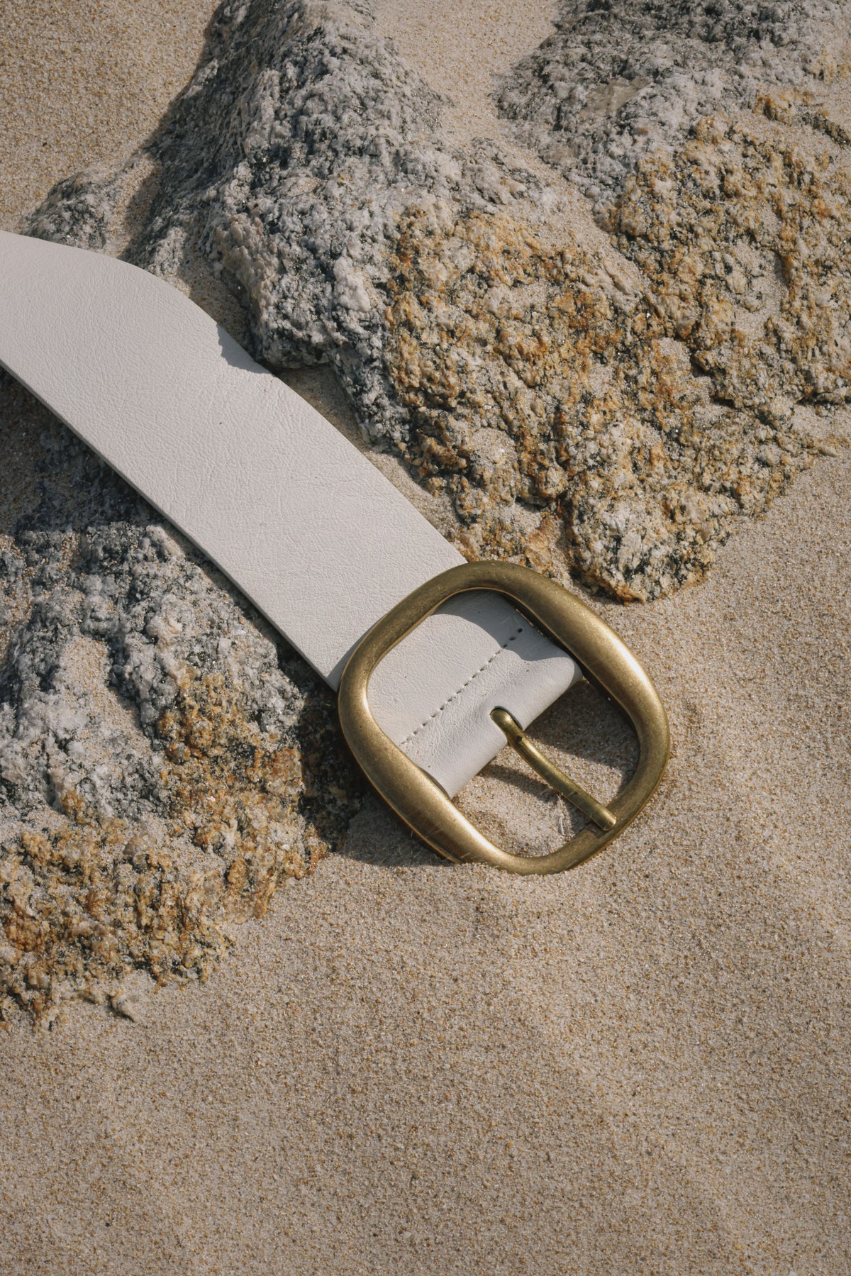 White Italian leather belt with brass-plated buckle, handcrafted in Los Angeles using custom hardware