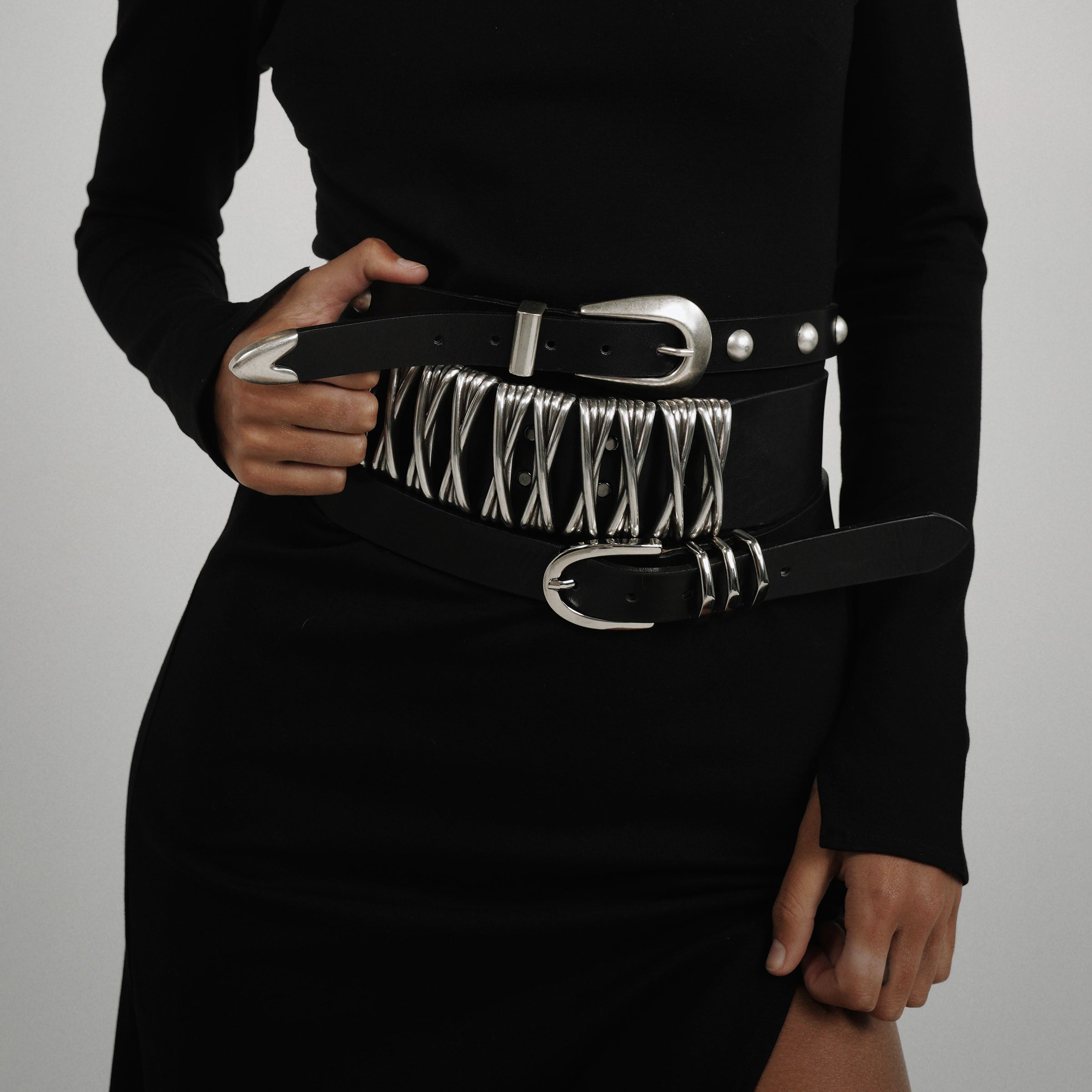 Close-up of silver interwoven hardware on the XXX Belt crafted in black Italian leather.