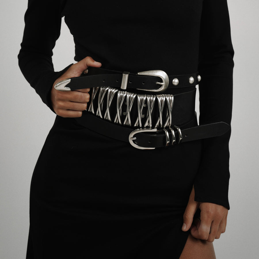 Close-up of silver interwoven hardware on the XXX Belt crafted in black Italian leather.