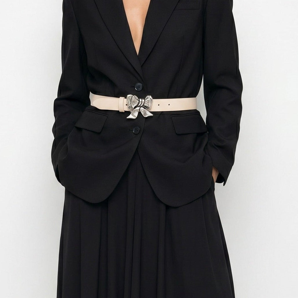 Woman wearing a black evening gown with a belt on a white background