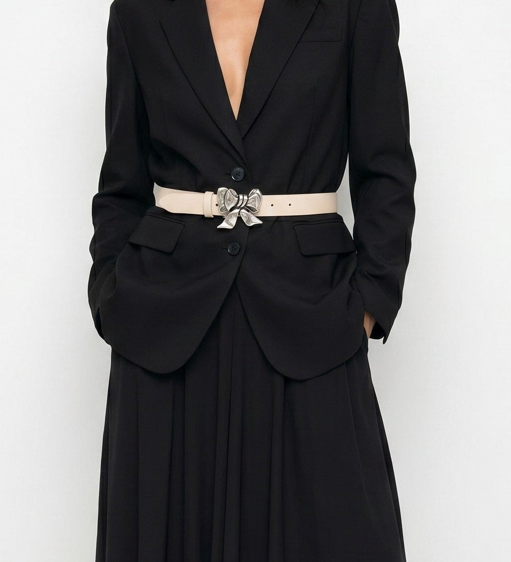 Woman wearing a black evening gown with a belt on a white background