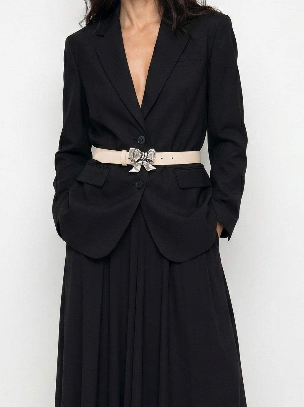 Woman wearing a black evening gown with a belt on a white background