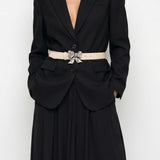 Woman wearing a black evening gown with a belt on a white background