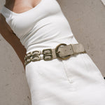 Saskia Belt in shimmer ivory Italian leather with solid brass buckle, worn over a white mini skirt