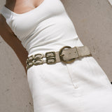 Saskia Belt in shimmer ivory Italian leather with solid brass buckle, worn over a white mini skirt